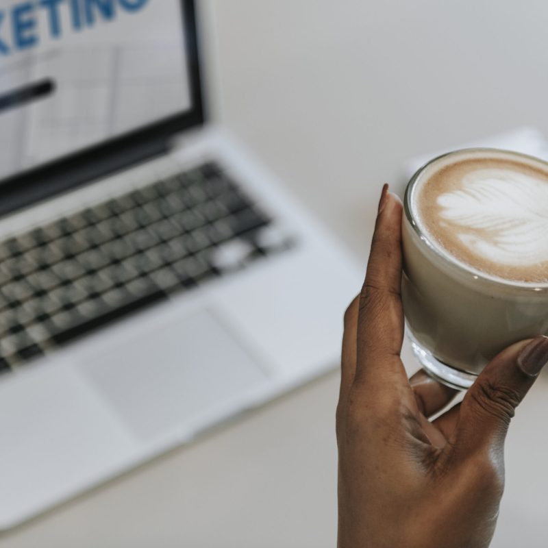 Woman sipping a cup of coffee while working